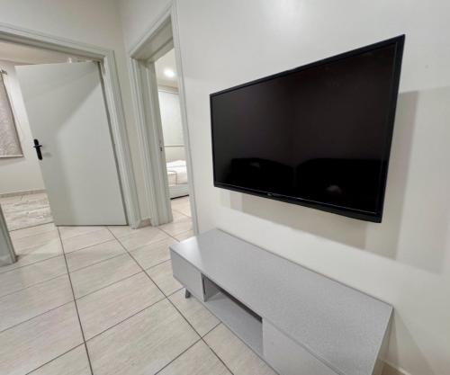 a living room with a flat screen tv on a wall at غرفتين نوم وصالة بدخول ذكي in Al Rass