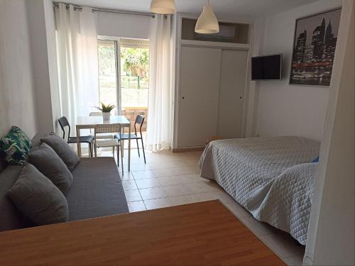 un soggiorno con un letto e un tavolo di Studio SeaGarden a Benalmádena