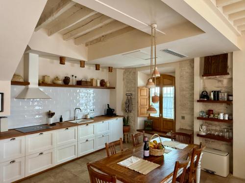Una cocina con una mesa de madera y un comedor. en Casa Amandava, en Salobreña