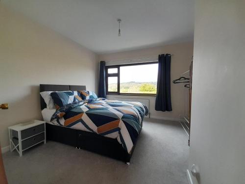 a bedroom with a bed and a window at Beltany Lodge in Mountjoy