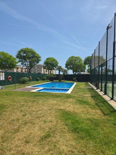 una piscina detrás de una valla en Piscina y Pádel al lado del Mar, en Torredembarra