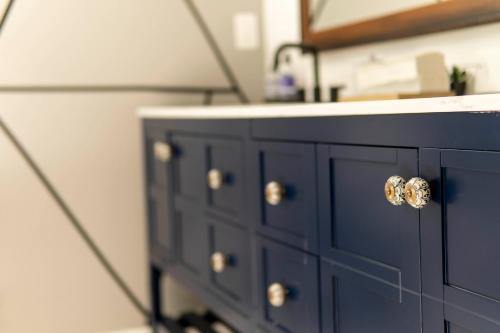 a blue bathroom cabinet with a sink and a mirror at A Cabin in the City with a 5 Star Lush Backyard in Atlanta