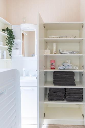 a bathroom with white shelves and a sink at higashibori five in Niigata