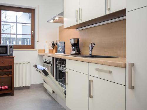 a kitchen with white cabinets and a sink at Bear Apartment am Skihang in Winterberg