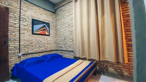 a bedroom with a blue bed in a brick wall at Privê Coqueiral in São José da Coroa Grande