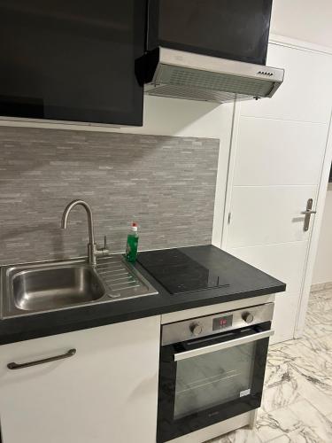 Il comprend une cuisine équipée d'un évier, d'une cuisinière et d'un évier. dans l'établissement Deux pièces au centre-ville proche des plages et centres commerciaux, à Saint-Laurent-du-Var