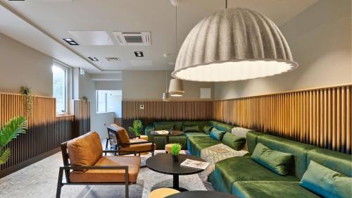 a living room with a green couch and a table at For Student Only - The Helix in Wembley in London