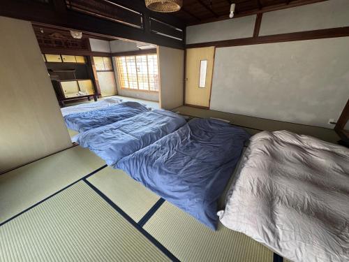 a room with two beds in it with a screen at 海と鉄 1日1組限定の宿 in Sukumo