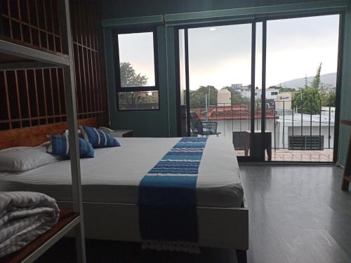 a bedroom with a bed and a large window at Hotel Momotus Tuxtla - Desayuno opcional in Tuxtla Gutiérrez