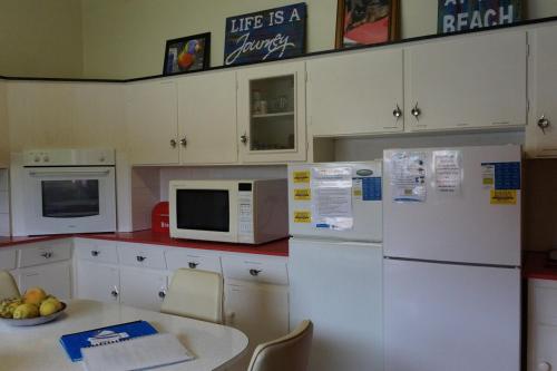 a kitchen with white appliances and a table with a bowl of fruit at La Vita in Wauraltee
