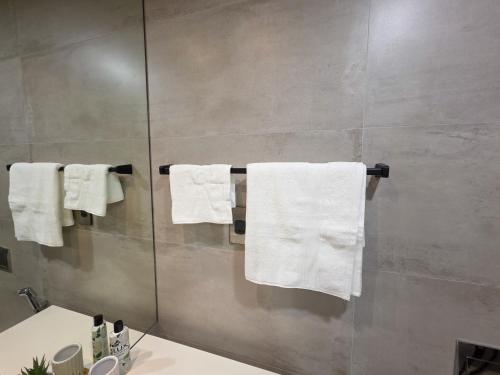 a bathroom with white towels hanging on a wall at Sea View Studio Perfect for Couples In Harbour Row in Manama
