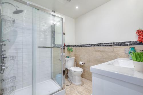 a bathroom with a shower and a toilet and a sink at The Elegant 3 Bedroom Residence in Barrie