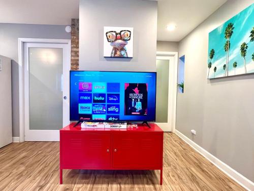 a red entertainment center with a flat screen tv in a room at Bridgeport Place - free parking, McCormick Place-Sox Park in Chicago