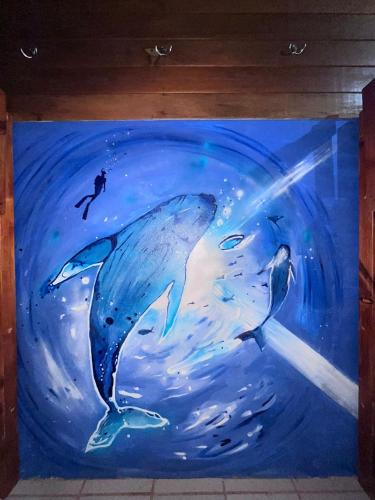 a painting of two dolphins in the water at fenix soul hostel ocean view in Drake