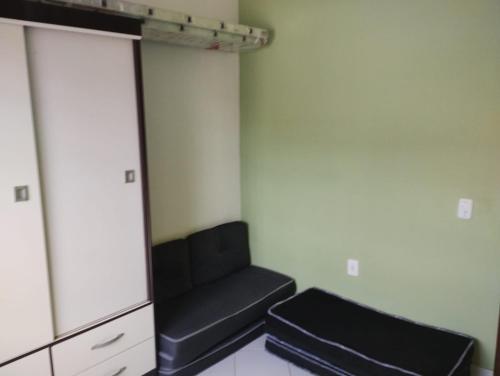 a living room with a black couch and a cabinet at Ótima Casa em Muriqui in Mangaratiba