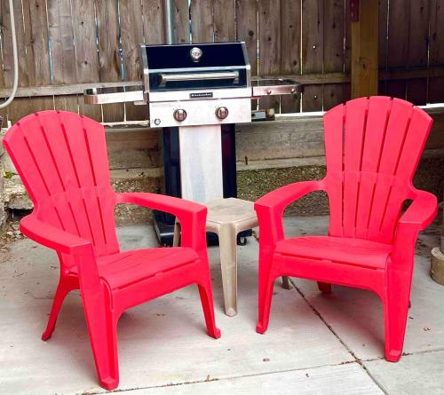 two red chairs and a table with a stove at Bridgeport Place - free parking, McCormick Place-Sox Park in Chicago
