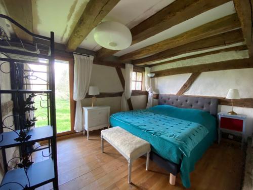 une chambre avec un lit vert et une fenêtre dans l'établissement La Maison du Pressoir, à Savigny-en-Sancerre
