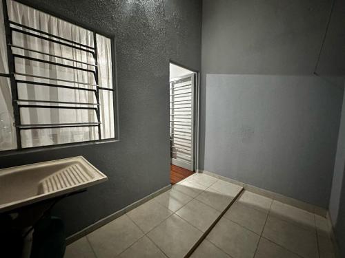 an empty bathroom with a sink and a window at Casa em Condomínio no Centro de Ponta Porã in Ponta Porã