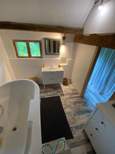 une salle de bain avec une baignoire blanche et un lavabo dans l'établissement La Maison du Pressoir, à Savigny-en-Sancerre