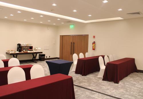a room with red and white tables and chairs at Holiday Inn Mexico Dali Airport by IHG in Mexico City