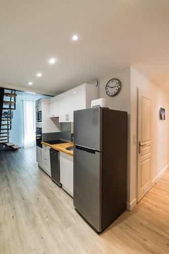 Il comprend une cuisine équipée d'un réfrigérateur et d'une horloge murale. dans l'établissement Les Demeures de Castellane, à Marseille