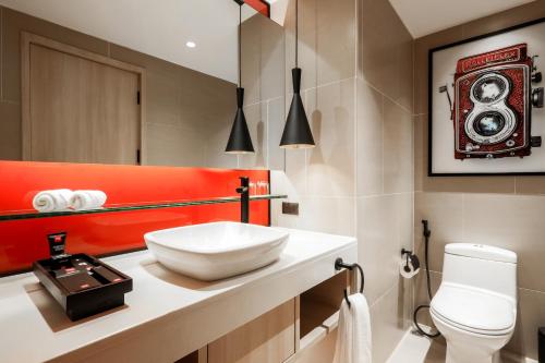 a bathroom with a white sink and a toilet at Radisson RED Phuket Patong Beach in Patong Beach
