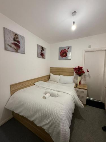 a bedroom with a large bed with white sheets at Kingsley Park Bridge Rooms in Northampton