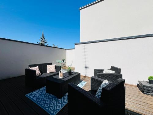 un patio avec deux canapés, une table et des chaises dans l'établissement Casa Belfort - T2, à Angers