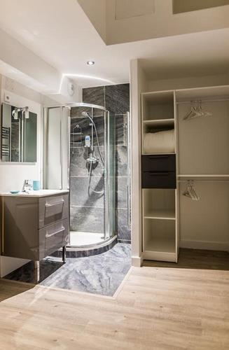 une salle de bain avec une douche, un lavabo et un miroir dans l'établissement Les Demeures de Castellane, à Marseille