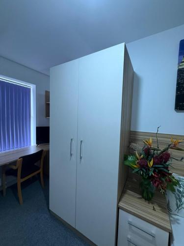 a room with a large cabinet with a vase of flowers on it at Kingsley Park Bridge Rooms in Northampton