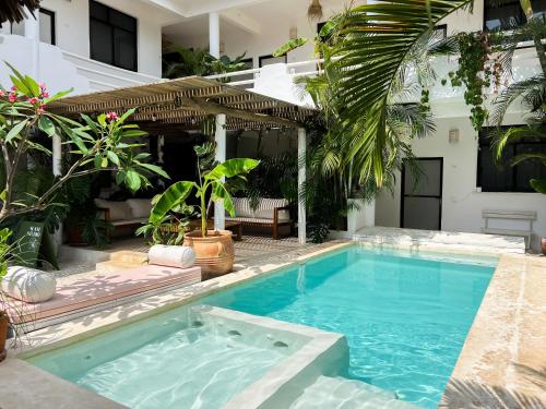 a swimming pool in front of a house at La Punta Rooms in Brisas de Zicatela