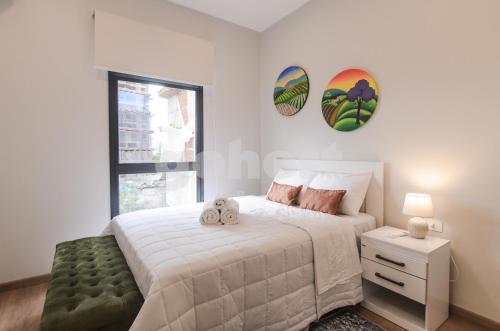 a white bedroom with a bed and a window at Luxurious 2 Bed Apt W Gym & Pool In Villa Morra in Asuncion