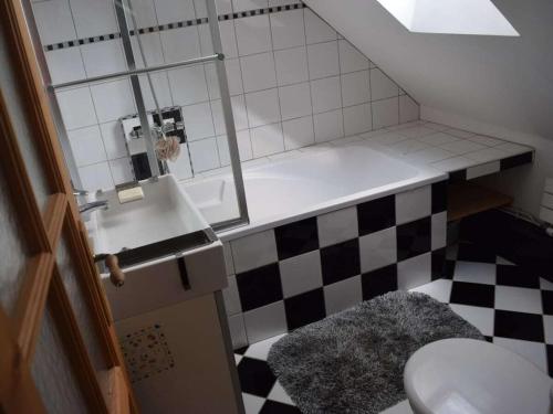 La salle de bains est pourvue de toilettes et d'un sol en damier. dans l'établissement La Taupe is a traditional Norman stone house, à Portbail