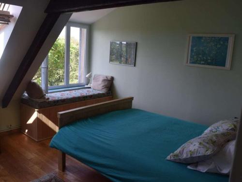 une chambre avec un lit et une fenêtre dans l'établissement La Taupe is a traditional Norman stone house, à Portbail