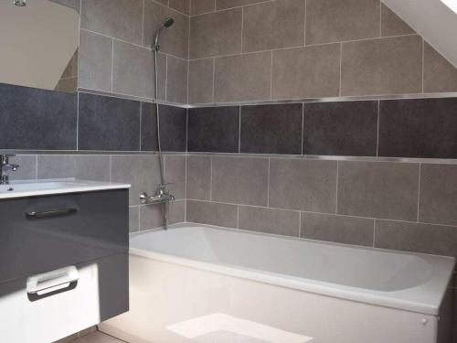 une salle de bain avec une baignoire blanche et un lavabo dans l'établissement Holiday cottage with 2 bedrooms, à Saint-Lo-dʼOurville