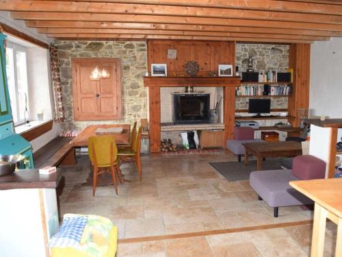 un salon avec une table et une cheminée dans l'établissement La Taupe is a traditional Norman stone house, à Portbail