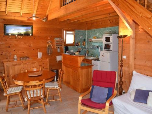 une cuisine avec une table et des chaises dans une cabine dans l'établissement Le Chalet Lindbergh, à Denneville-Plage