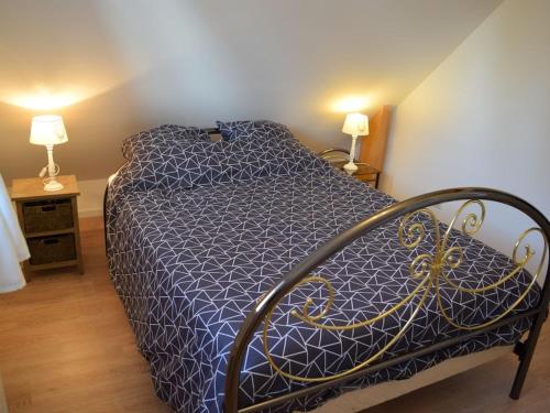 une chambre avec un lit avec une couette bleue dans l'établissement Holiday cottage with 2 bedrooms, à Denneville