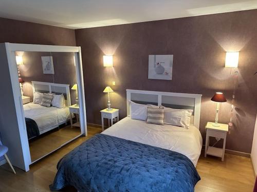 une chambre avec deux lits et un grand miroir dans l'établissement The Red House near the beach, à Denneville-Plage