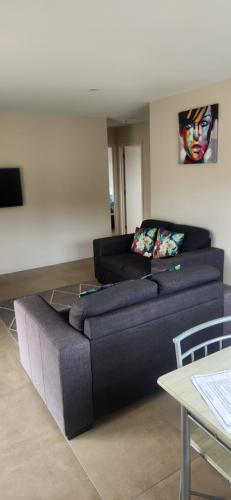 a living room with a couch and a table at Pinegrove Cottages - unit3 in Twizel