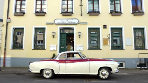a red and white car parked in front of a building at Romantisches Hotel Zur Traube Schwerin in Schwerin