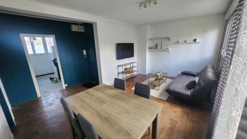 un salon avec une table et un canapé dans l'établissement apartment 8 people 24H Le Mans, au Mans
