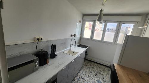d'une cuisine avec un comptoir, un évier et une fenêtre. dans l'établissement apartment 8 people 24H Le Mans, au Mans