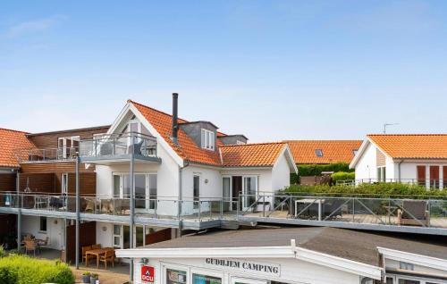 a row of white houses with orange roofs at Amazing Apartment In Gudhjem With Wifi in Gudhjem