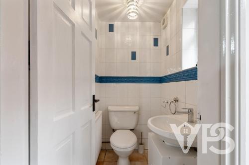 a white bathroom with a toilet and a sink at Contractors Family Near Hospital in Leicester