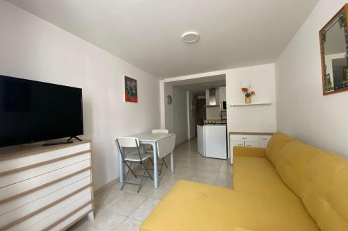 un salon avec un canapé jaune et une table dans l'établissement The Little Cambo, à Cambo-les-Bains