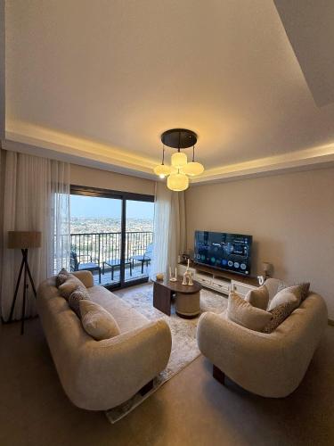a living room with two couches and a television at شقة فندقية أبراج زد الشيخ زايد القاهرة Zed Towers in Sheikh Zayed