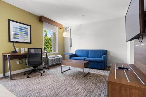 a living room with a blue couch and a desk at Holiday Inn Express and Suites Surrey by IHG in Surrey
