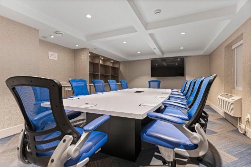 a conference room with a table and blue chairs at Holiday Inn Express and Suites Surrey by IHG in Surrey