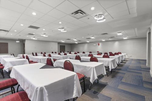 a conference room with white tables and red chairs at Holiday Inn Express and Suites Surrey by IHG in Surrey